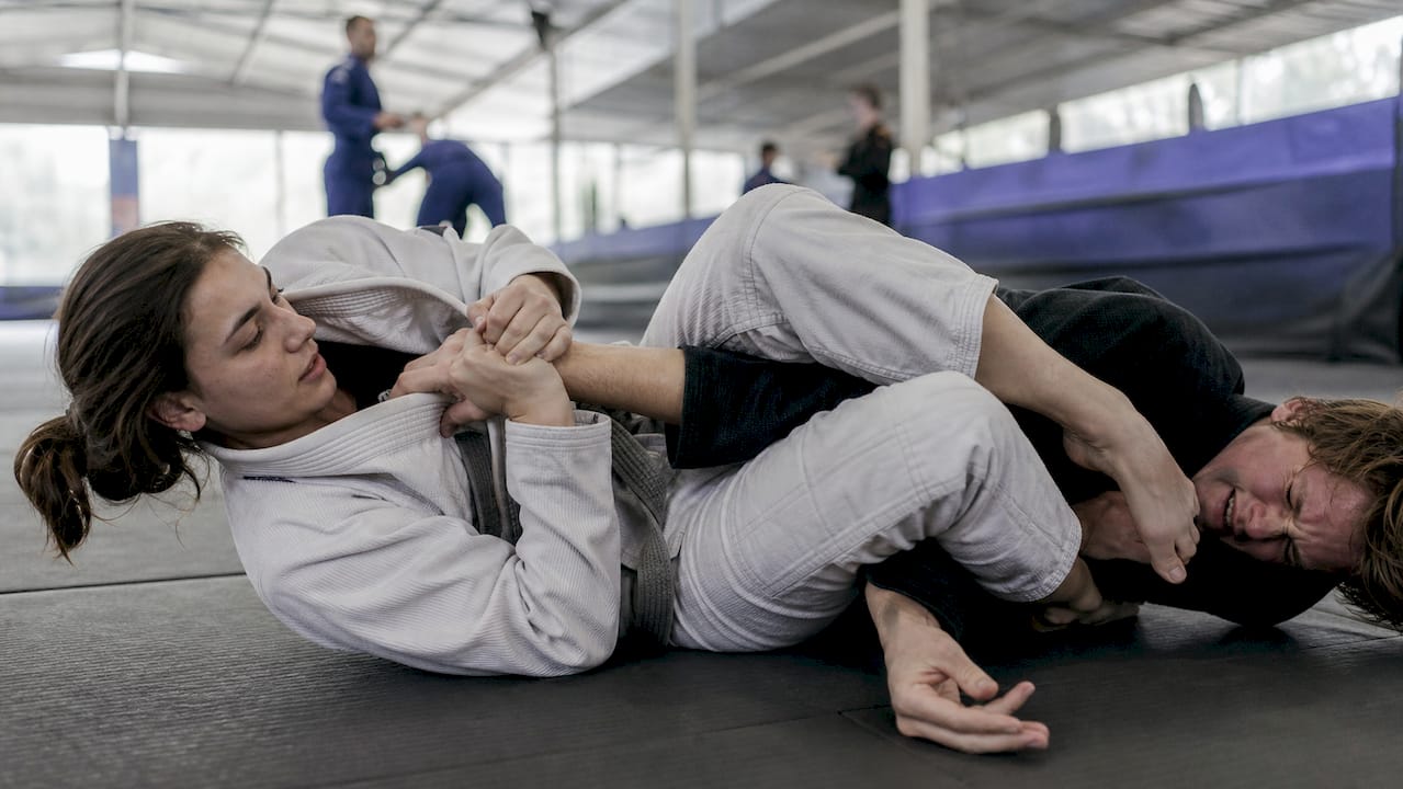 Een beginner die een armklem uitvoert vanuit de guard-positie